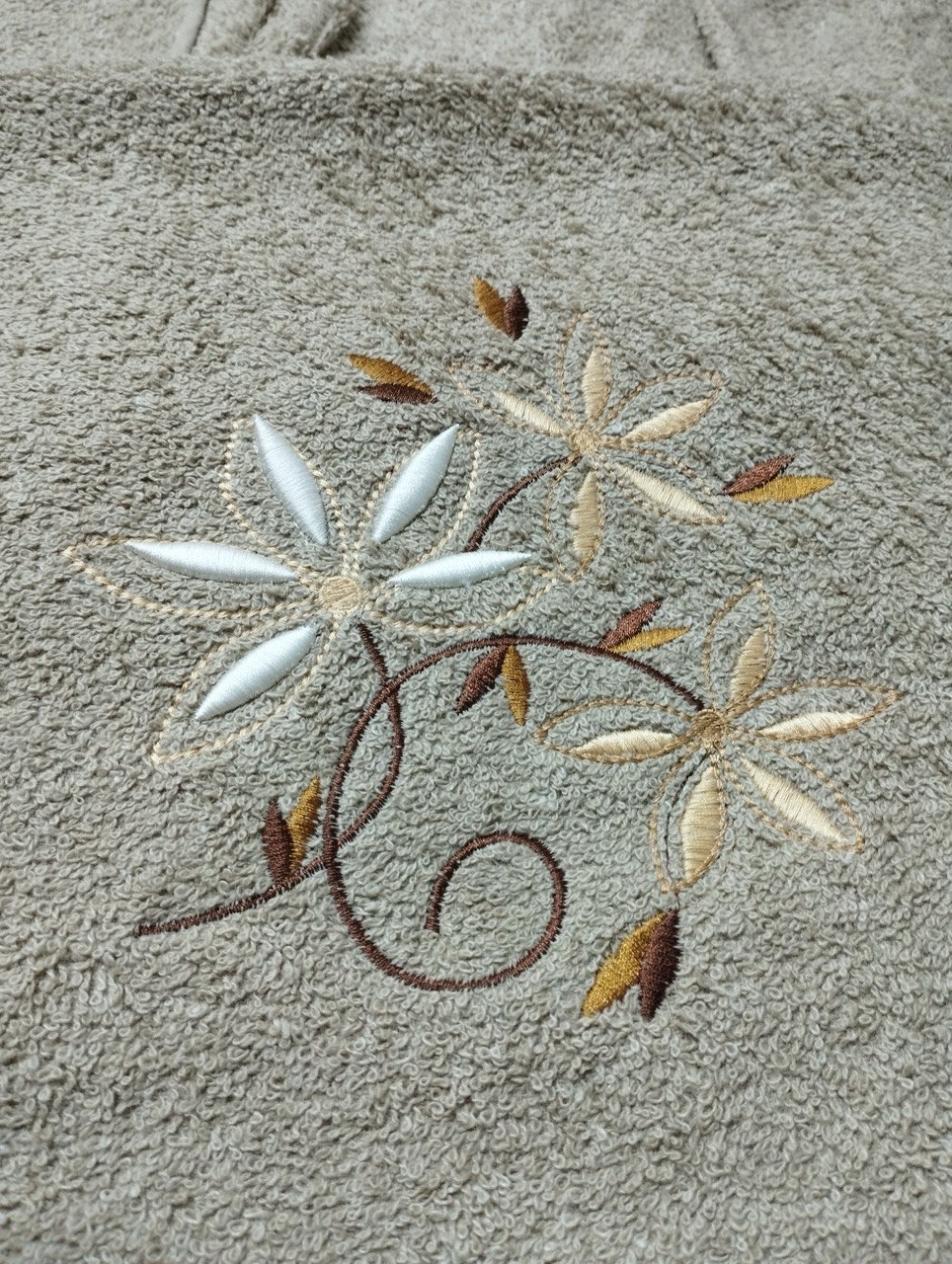 Cream and gold floral embroidery on bath towel, hand-digitized and stitched